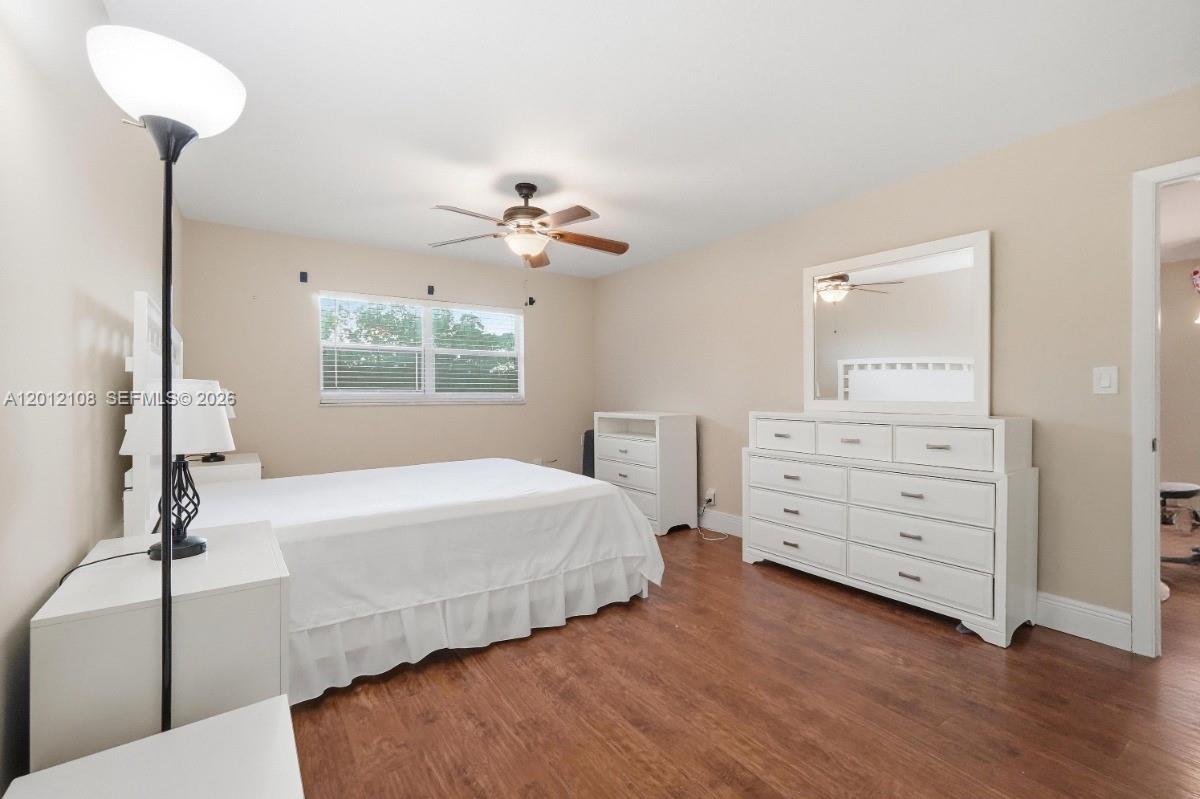 8826 West McNab Road, Unit 304 Tamarac, FL 33321 - Photo 15 of 22 a bedroom with bed and a chandelier