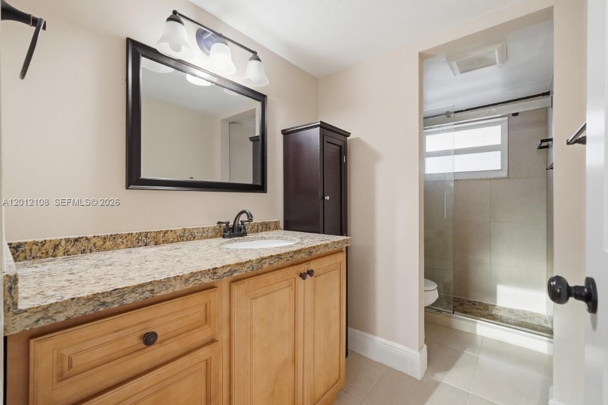 8826 West McNab Road, Unit 304 Tamarac, FL 33321 - Photo 16 of 22 a bathroom with a granite countertop sink and a mirror