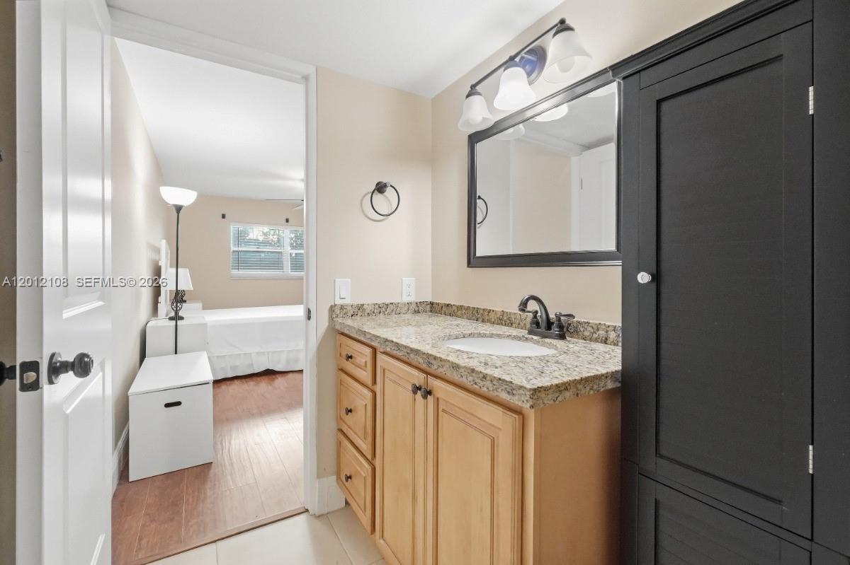 8826 West McNab Road, Unit 304 Tamarac, FL 33321 - Photo 17 of 22 a spacious bathroom with a granite countertop sink and a mirror