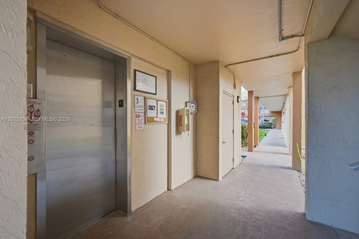 8826 West McNab Road, Unit 304 Tamarac, FL 33321 - Photo 20 of 22 a view of a hallway with wooden shelves