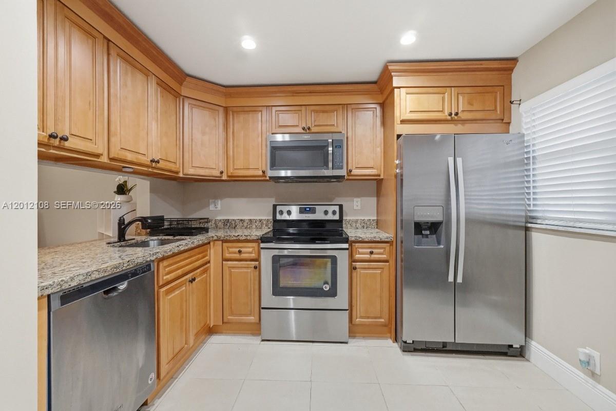 8826 West McNab Road, Unit 304 Tamarac, FL 33321 - Photo 3 of 22 a kitchen with stainless steel appliances granite countertop a stove a sink and a refrigerator