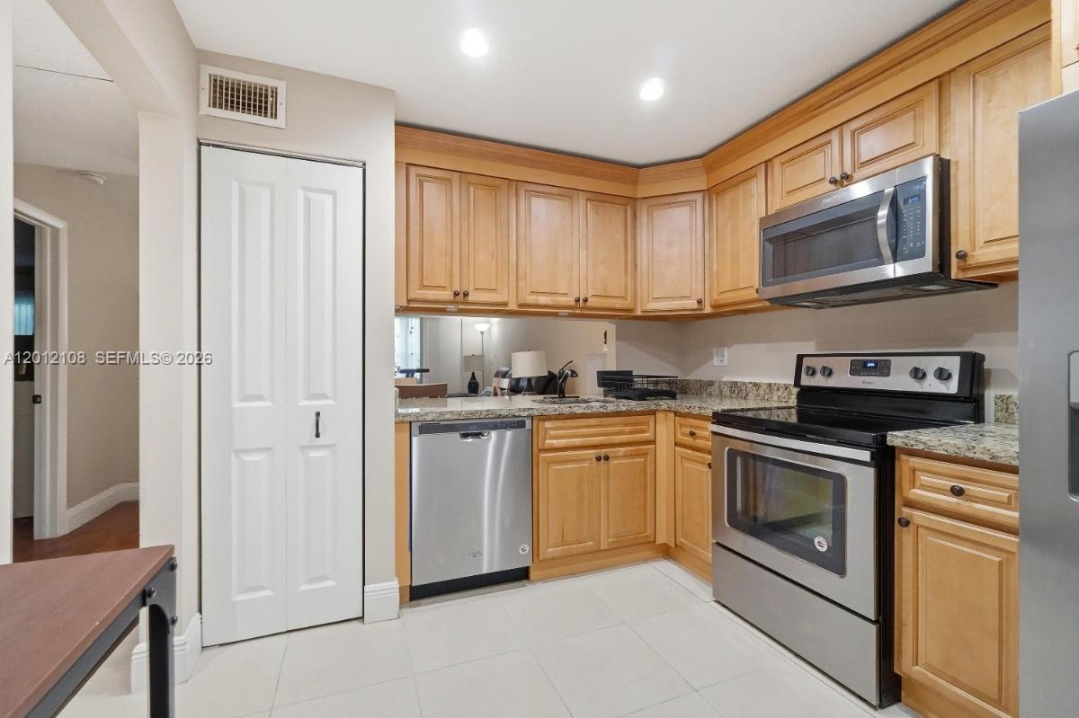 8826 West McNab Road, Unit 304 Tamarac, FL 33321 - Photo 4 of 22 a kitchen with stainless steel appliances granite countertop a stove a sink and a refrigerator