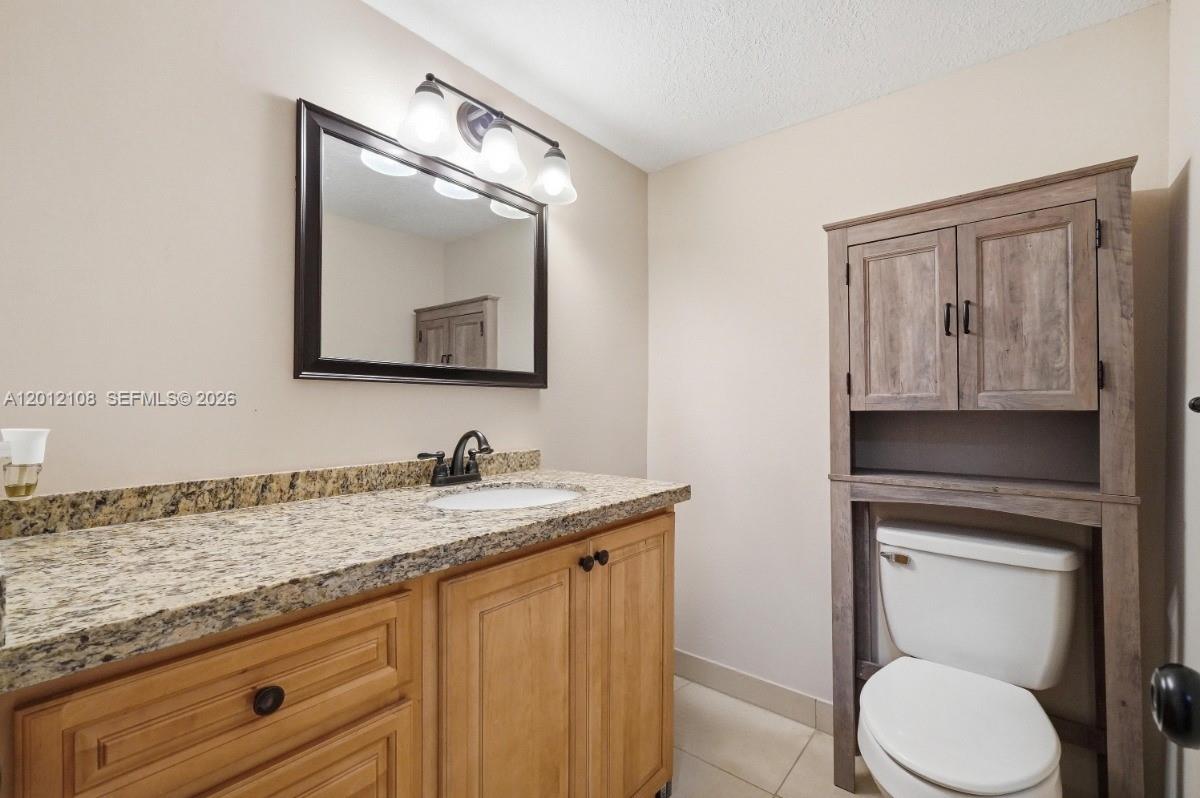 8826 West McNab Road, Unit 304 Tamarac, FL 33321 - Photo 6 of 22 a bathroom with a toilet a sink and mirror