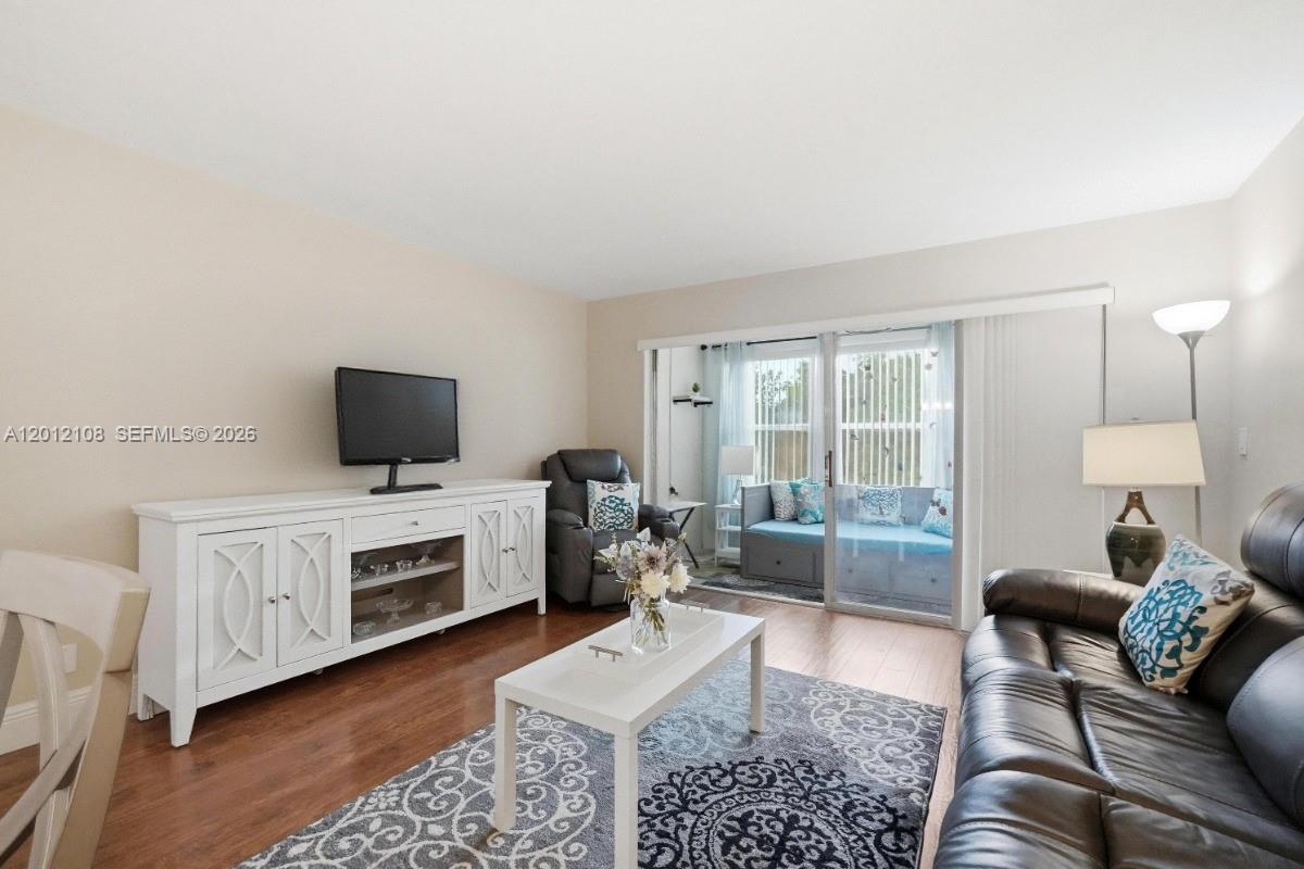 8826 West McNab Road, Unit 304 Tamarac, FL 33321 - Photo 8 of 22 a living room with furniture and a flat screen tv