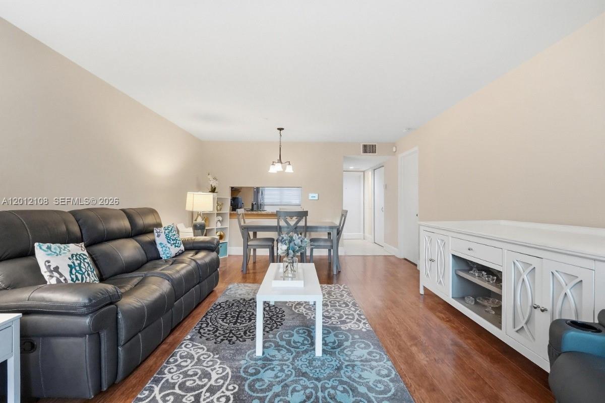 8826 West McNab Road, Unit 304 Tamarac, FL 33321 - Photo 9 of 22 a living room with furniture and a wooden floor