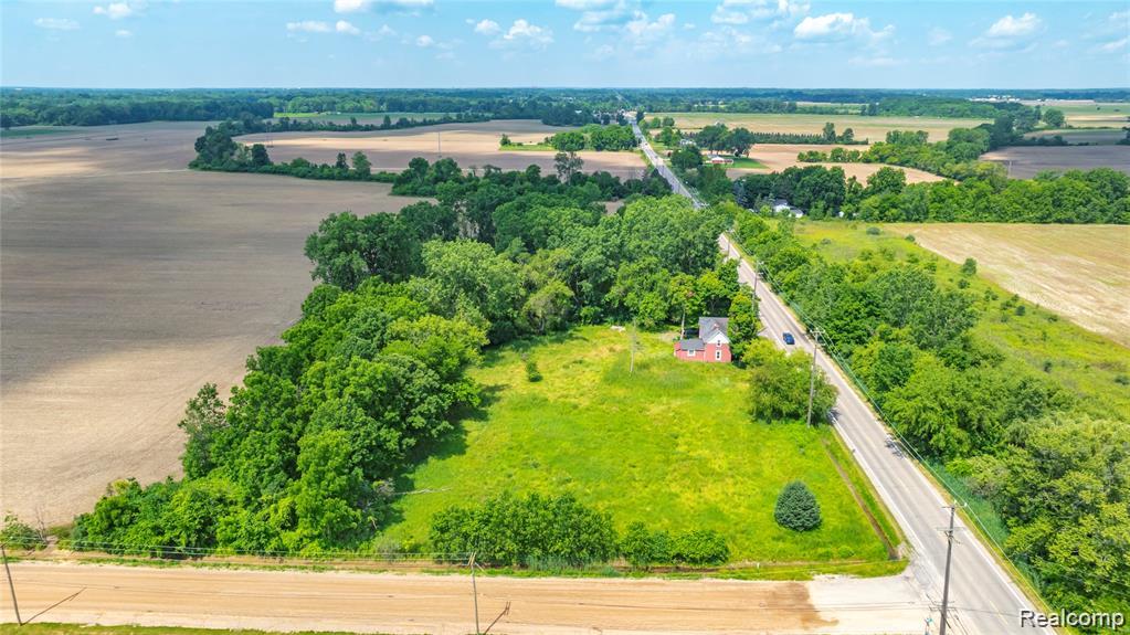 50505 Geddes Road Canton, MI 48188 - Photo 1 of 1 Expansive property featuring a single-story residence with a red roof, surrounded by mature trees and open fields