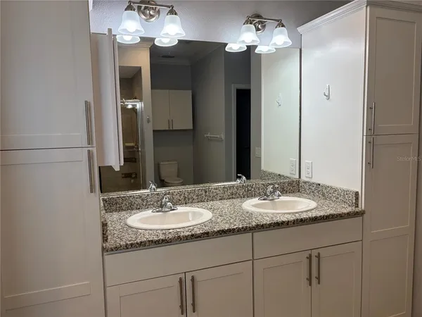 a bathroom with a granite countertop sink and a mirror