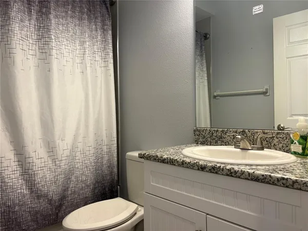 a bathroom with a granite countertop sink toilet and shower