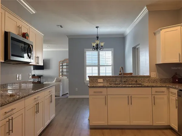 a kitchen with stainless steel appliances granite countertop a sink stove and microwave