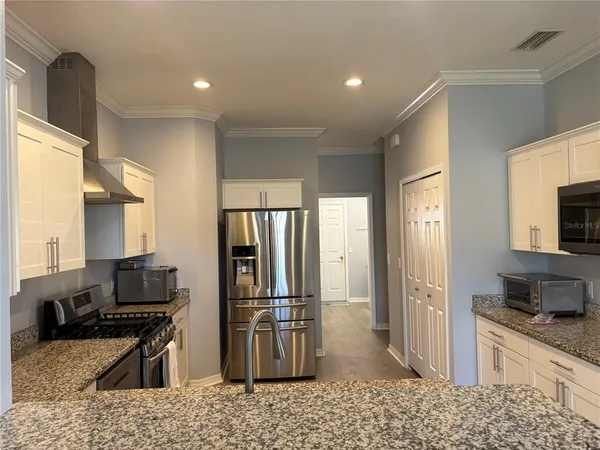 a kitchen with stainless steel appliances kitchen island granite countertop a refrigerator stove and sink