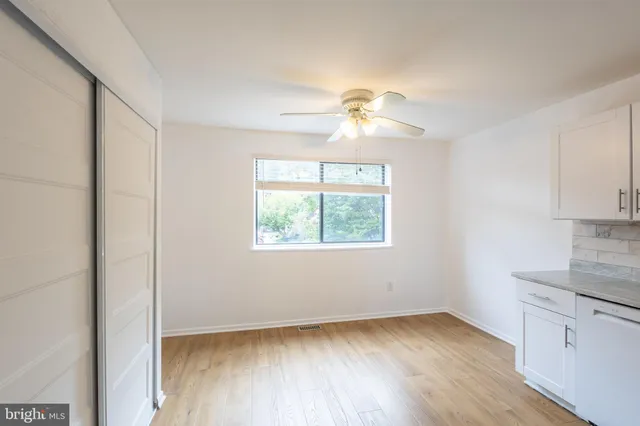 an empty room with windows and fan
