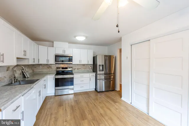 a kitchen with stainless steel appliances granite countertop a refrigerator sink and stove