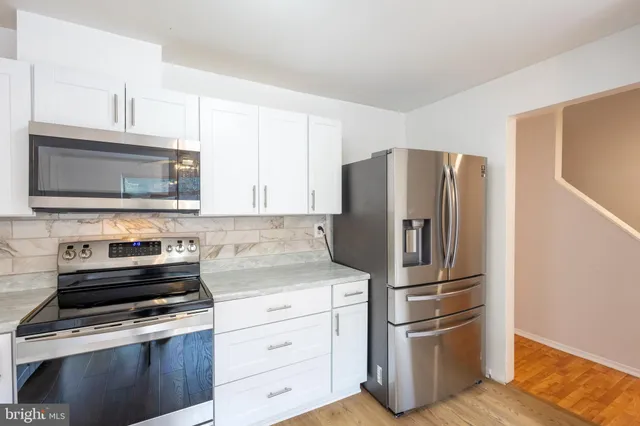 a kitchen with stainless steel appliances a refrigerator stove and microwave