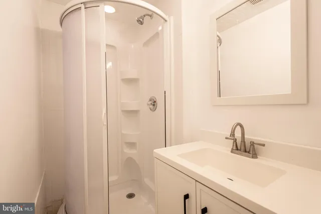 a bathroom with a sink a mirror and shower