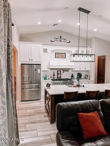 a kitchen with stainless steel appliances granite countertop a refrigerator and a stove