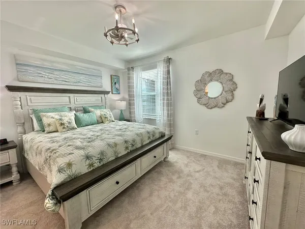 a bed sitting in a bedroom next to a window and a chair
