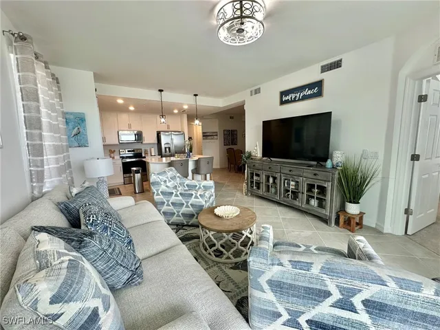 a living room with furniture a flat screen tv and a large window