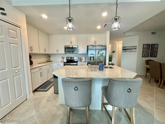 a kitchen with kitchen island granite countertop a sink a center island and cabinets