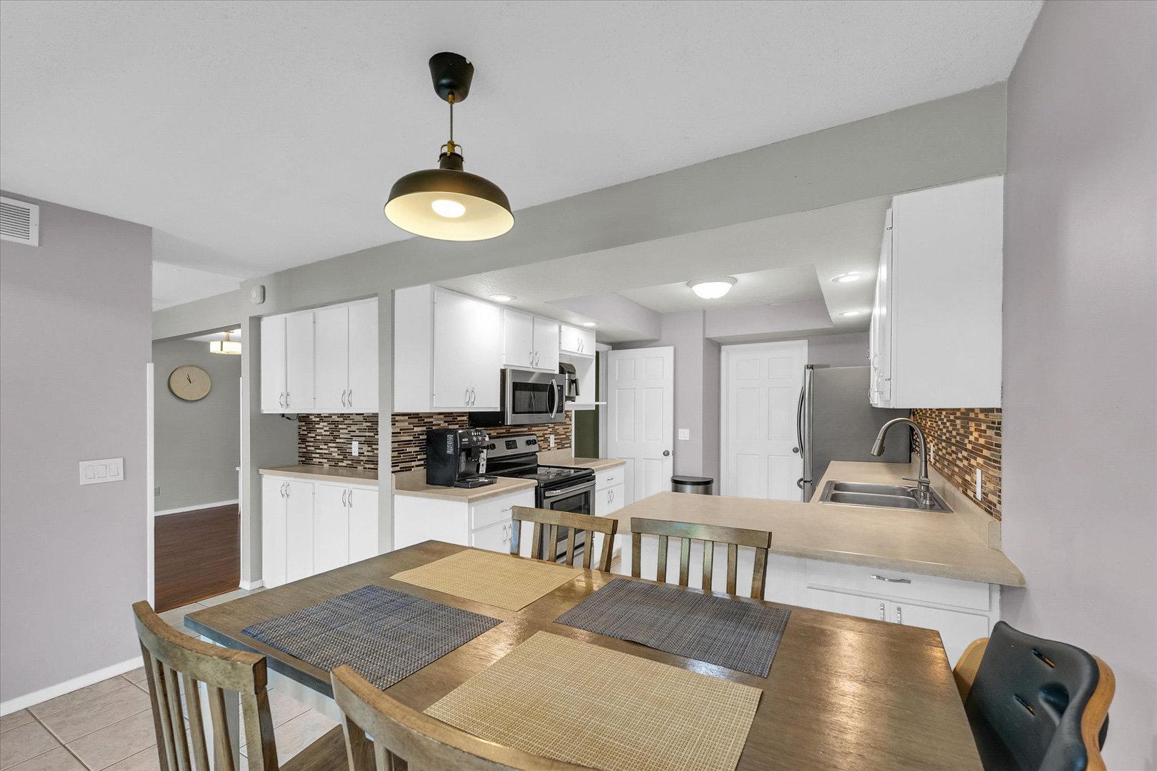 1727 Devonshire Drive Champaign, IL 61821 - Photo 22 of 48 a kitchen with stainless steel appliances granite countertop a stove a refrigerator a oven a sink a dining table and chairs with wooden floor