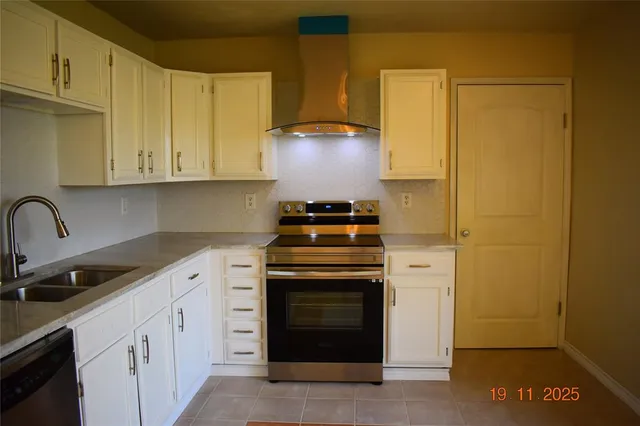 a kitchen with granite countertop white cabinets and stainless steel appliances