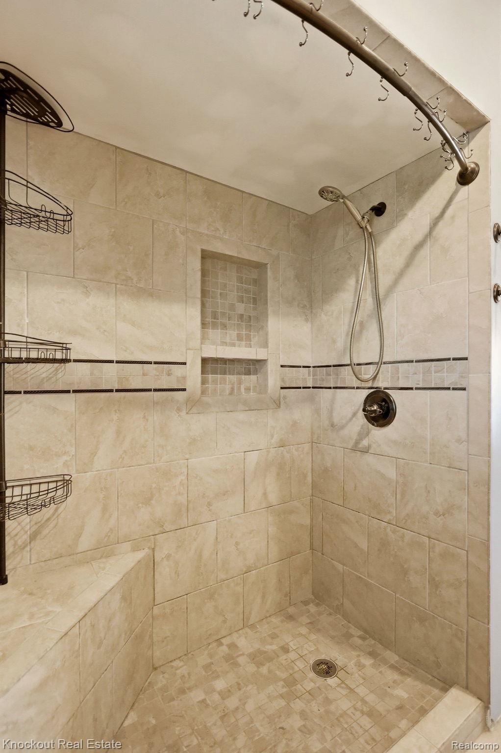 8811 Van Cleve Road Vassar, MI 48768 - Photo 20 of 39 Tiled shower with a built-in bench, recessed niche, and mosaic tile accents