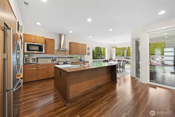a kitchen with stainless steel appliances kitchen island granite countertop a stove refrigerator and cabinets