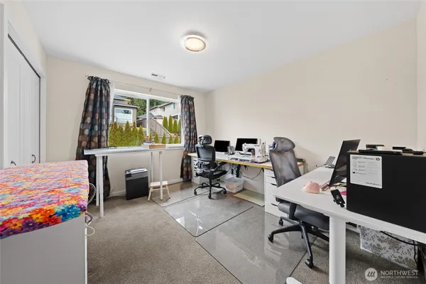 a bedroom with workspace and a window