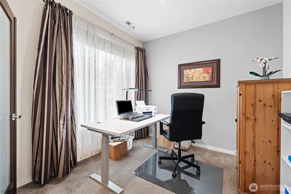 a view of a workspace with furniture and a window