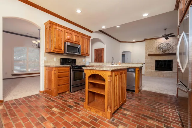 a kitchen with stainless steel appliances granite countertop a stove top oven and sink