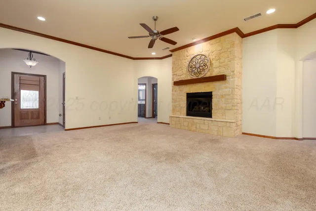 an empty room with ceiling fan and a fireplace