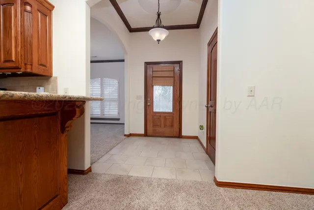 an empty room with chandelier fan and windows