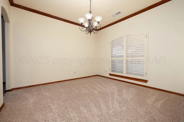 a view of an empty room with a chandelier