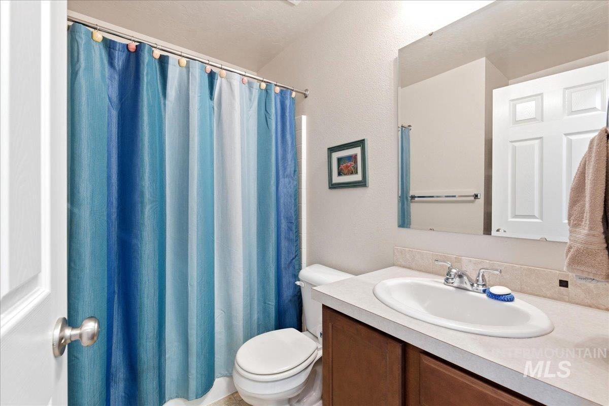 13622 Orlando Street Caldwell, ID 83607 - Photo 10 of 16 Bathroom with vanity, a shower with shower curtain, and a textured wall
