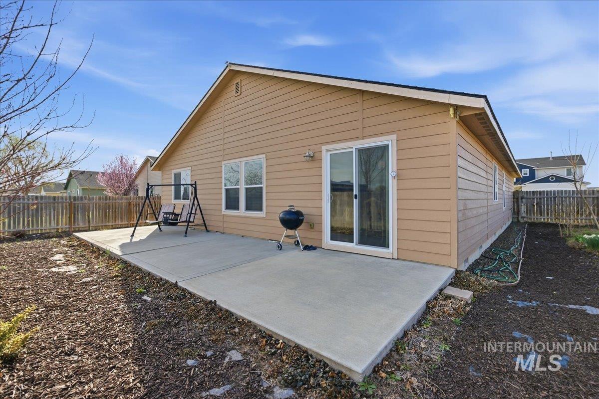 13622 Orlando Street Caldwell, ID 83607 - Photo 14 of 16 Rear view of property with a fenced backyard and a patio