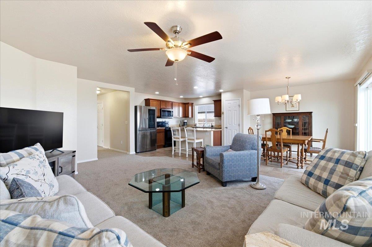 13622 Orlando Street Caldwell, ID 83607 - Photo 2 of 16 Living room featuring ceiling fan, suspended lighting, and light colored carpet