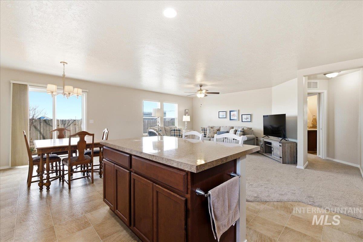 13622 Orlando Street Caldwell, ID 83607 - Photo 15 of 16 Kitchen featuring a kitchen island, open floor plan, light countertops, ceiling fan, and suspended lighting