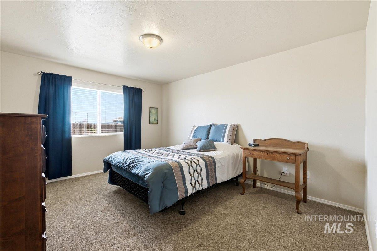 13622 Orlando Street Caldwell, ID 83607 - Photo 7 of 16 Bedroom with light colored carpet and a textured ceiling