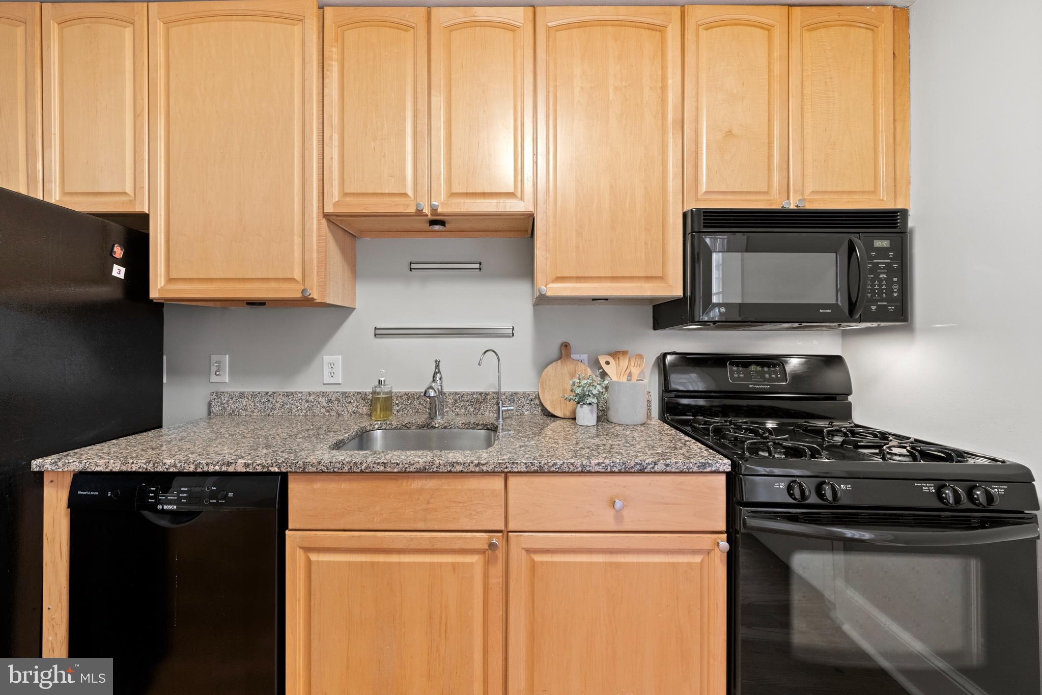718 13th Street Northeast Washington, DC 20002 - Photo 12 of 35 a kitchen with granite countertop a sink a stove and cabinets