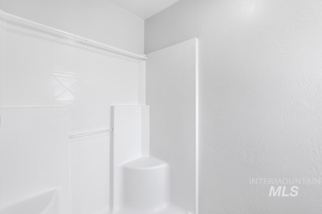 1183 Cortes Loop Twin Falls, ID 83301 - Photo 21 of 30 White shower enclosure with a built-in seat and integrated shelving