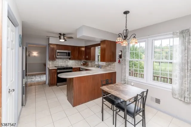 a kitchen with kitchen island a large counter top space appliances and cabinets