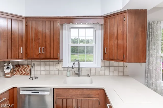 a kitchen with stainless steel appliances wooden cabinets a sink and a window
