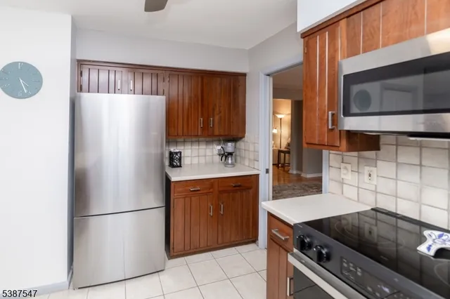 a kitchen with stainless steel appliances a refrigerator a stove a sink cabinets and a dining table