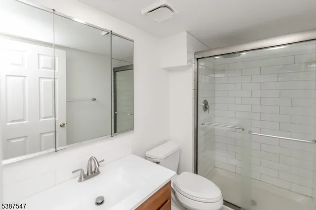a view of an empty room with wooden floor and a fireplace