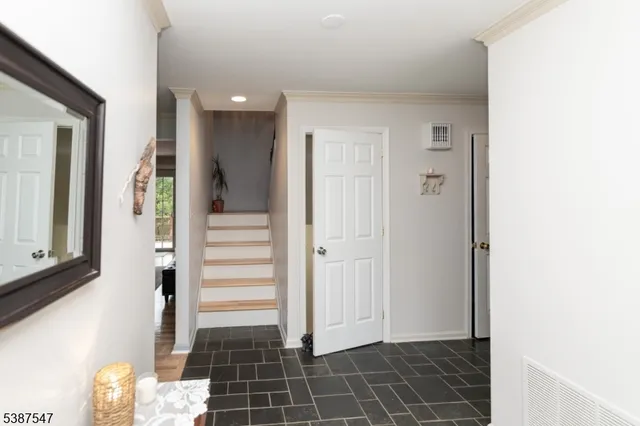 a view of a hallway with wooden cabinets and staircase