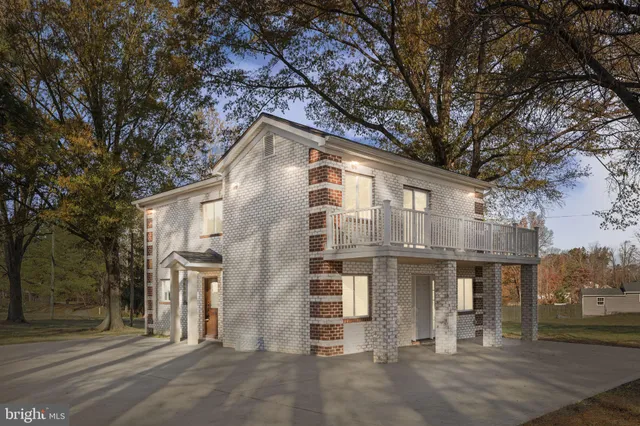 a front view of a house with a tree