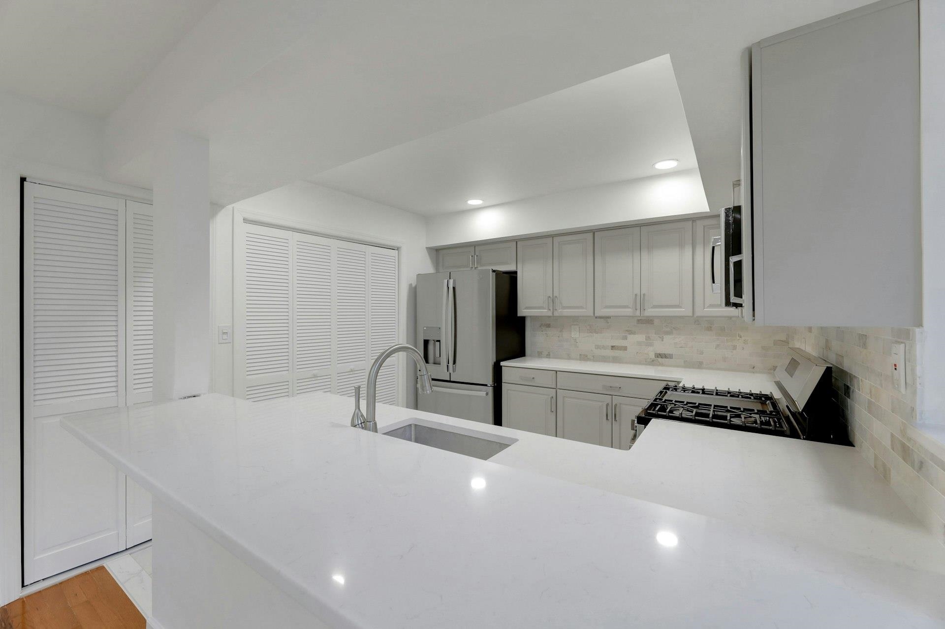 726 Mainsail Lane, Unit MAINSAIL LANE Secaucus, NJ 07094 - Photo 15 of 39 a large white kitchen with a sink and cabinets