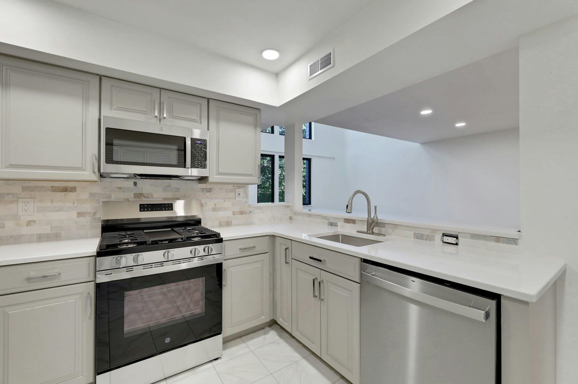 726 Mainsail Lane, Unit MAINSAIL LANE Secaucus, NJ 07094 - Photo 19 of 39 a kitchen with sink a microwave a stove and cabinets