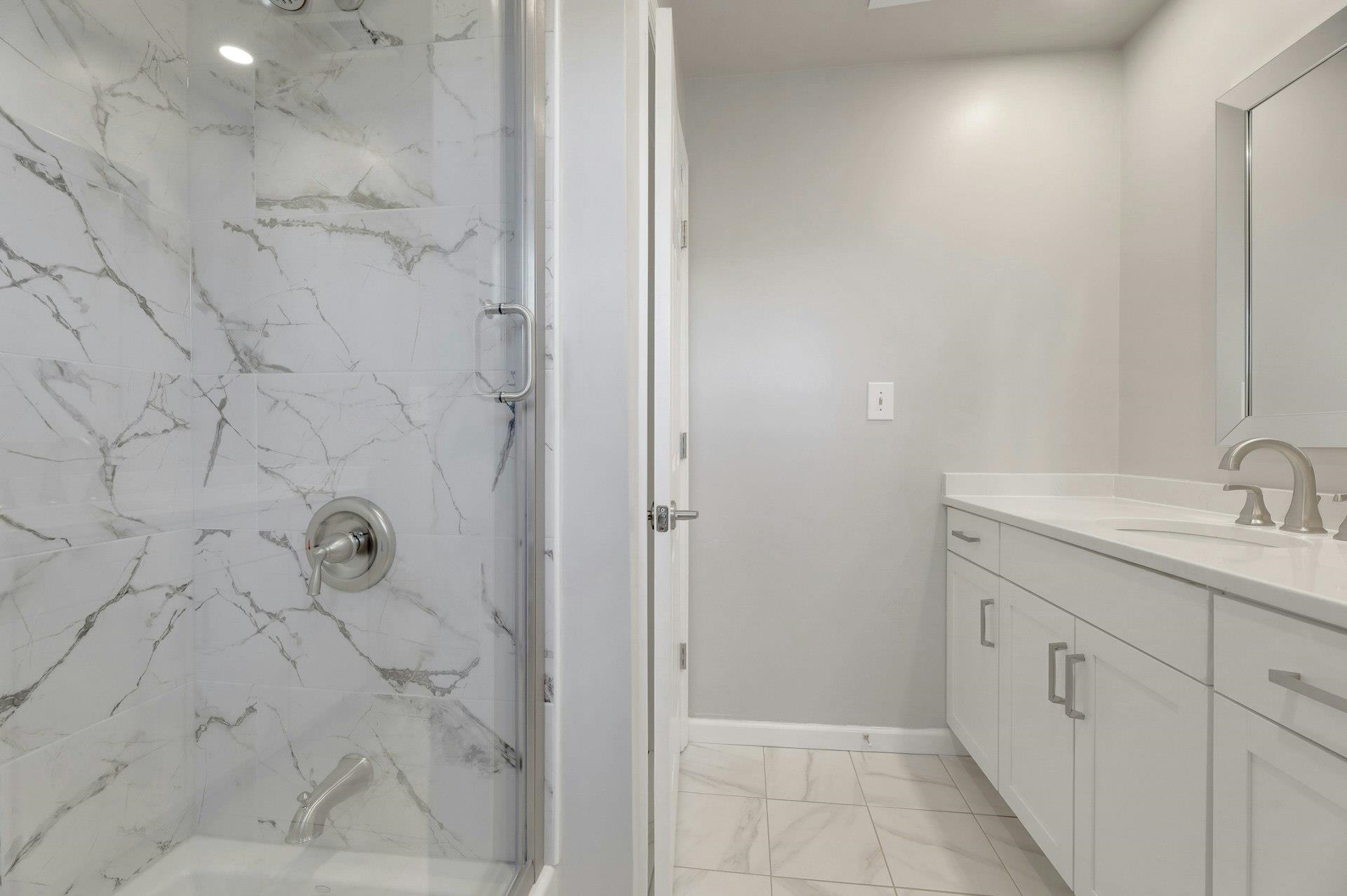 726 Mainsail Lane, Unit MAINSAIL LANE Secaucus, NJ 07094 - Photo 35 of 39 a bathroom with a granite countertop sink a shower and a mirror