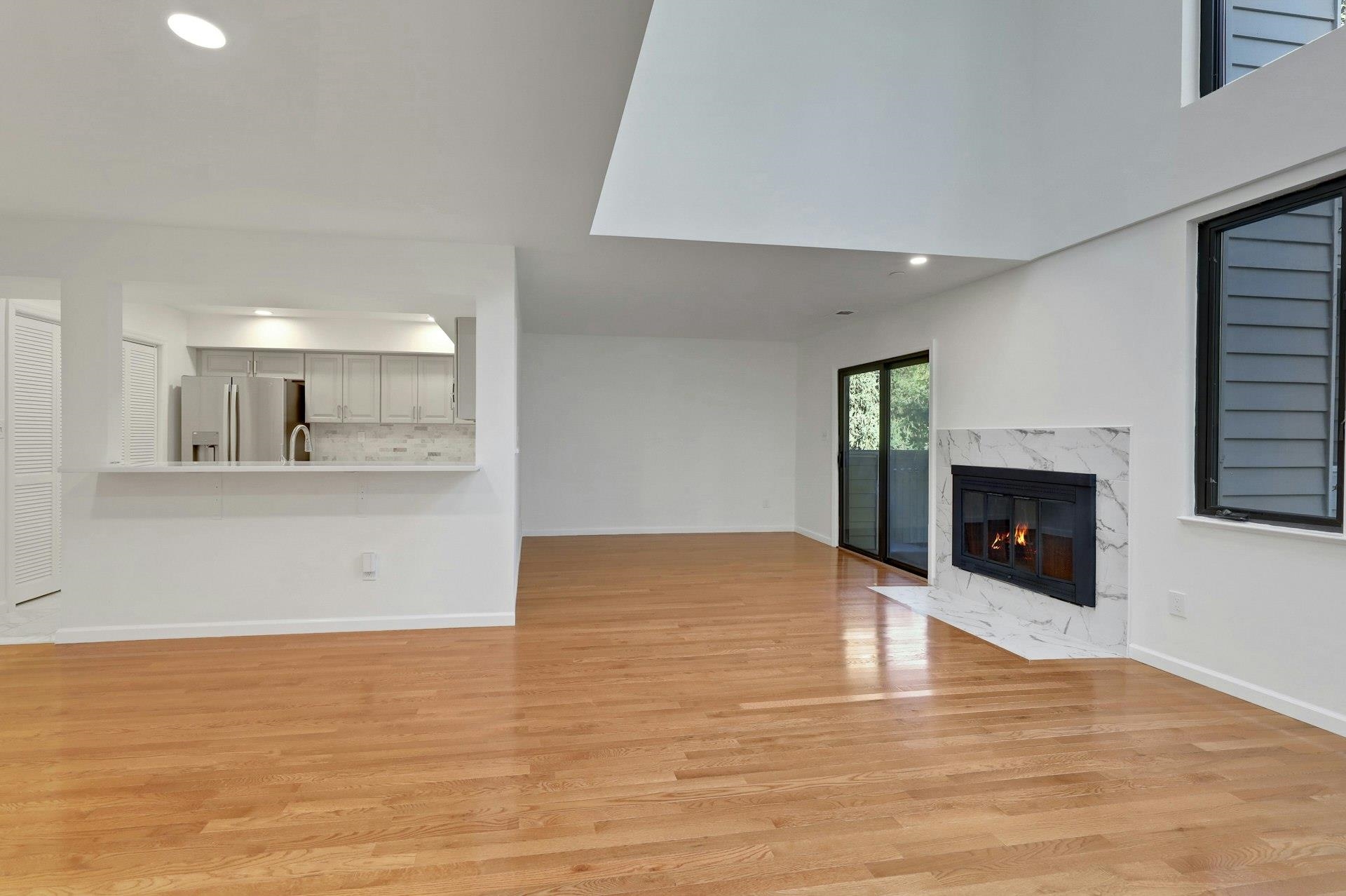 726 Mainsail Lane, Unit MAINSAIL LANE Secaucus, NJ 07094 - Photo 7 of 39 a view of kitchen and empty room with wooden floor and fireplace