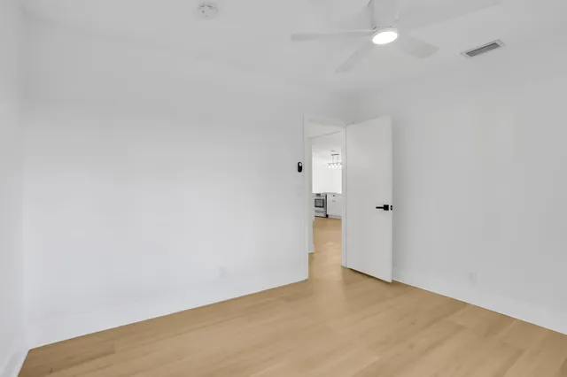 an empty room with a fan & a ceiling fan